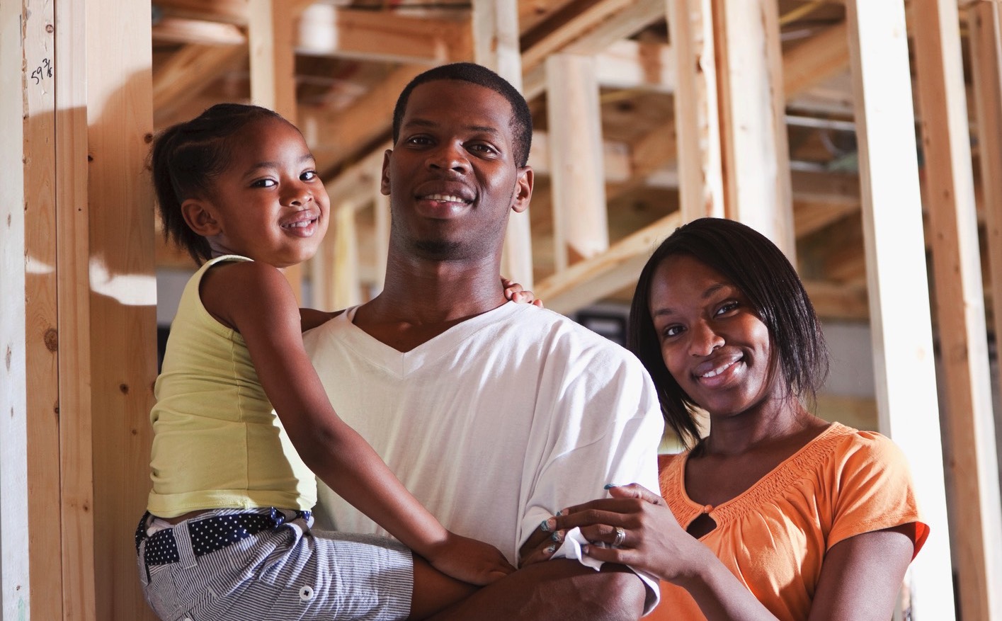 Happy african american family at the new house construction site.