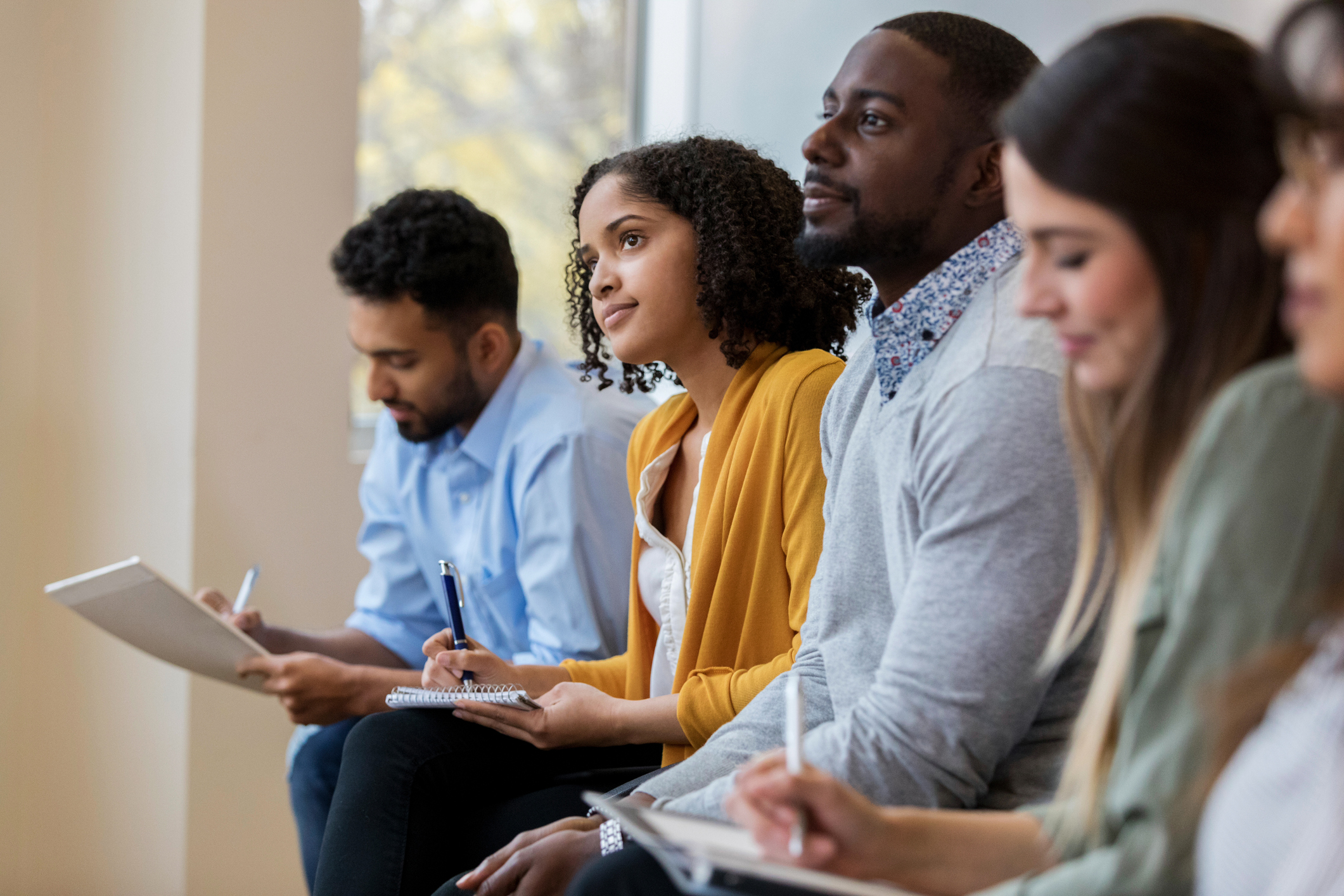 Group of people taking notes at a meeting.