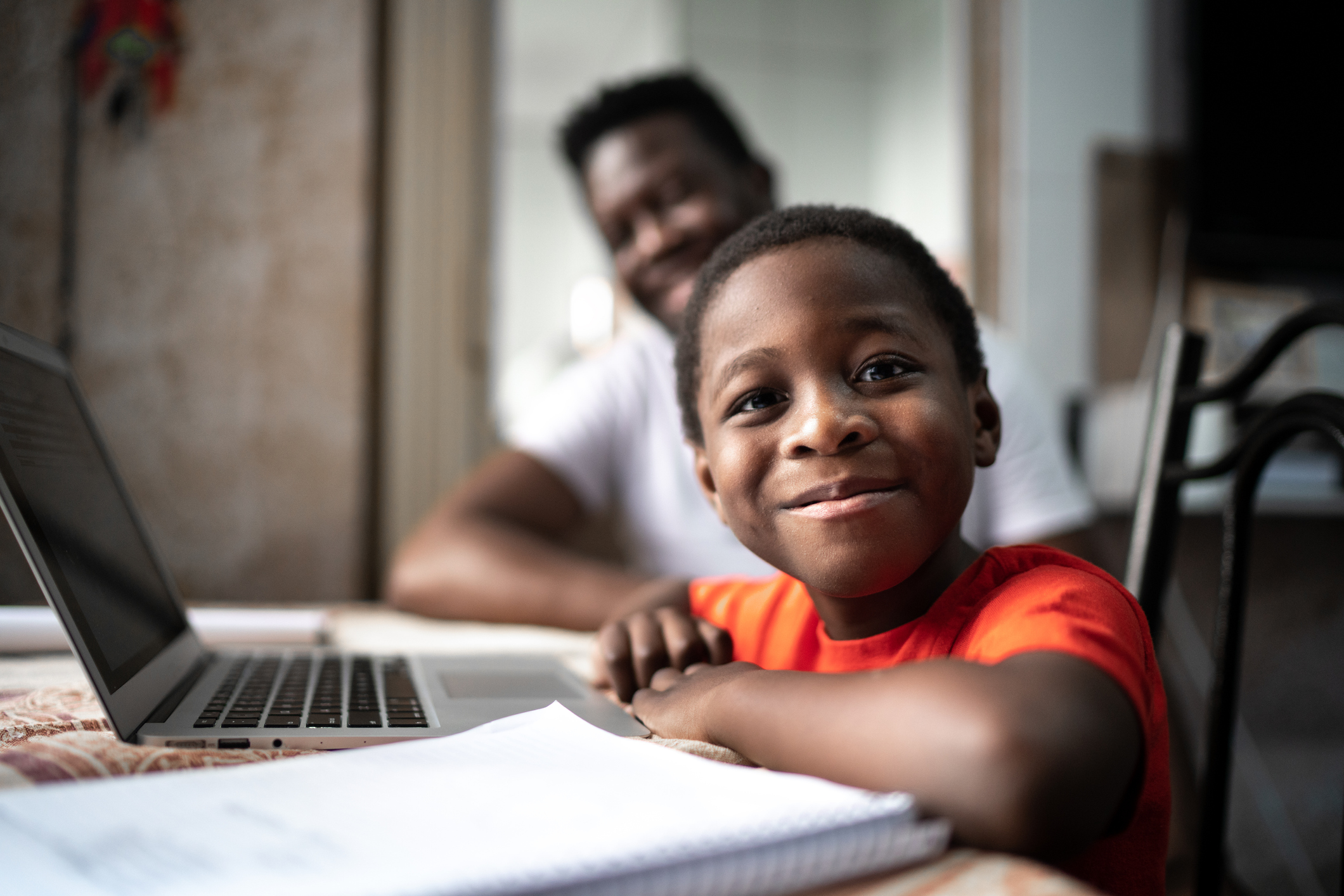 Picture of a smiling child in front of the laptop.