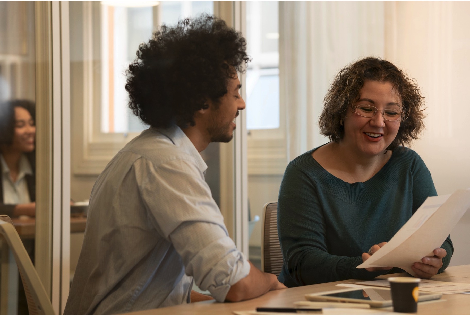 Two people at the table discussing.